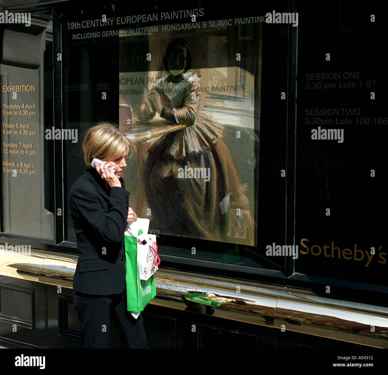 Sothebys fine art auction house facade and mobile phone user Bond Street London  Stock Photo