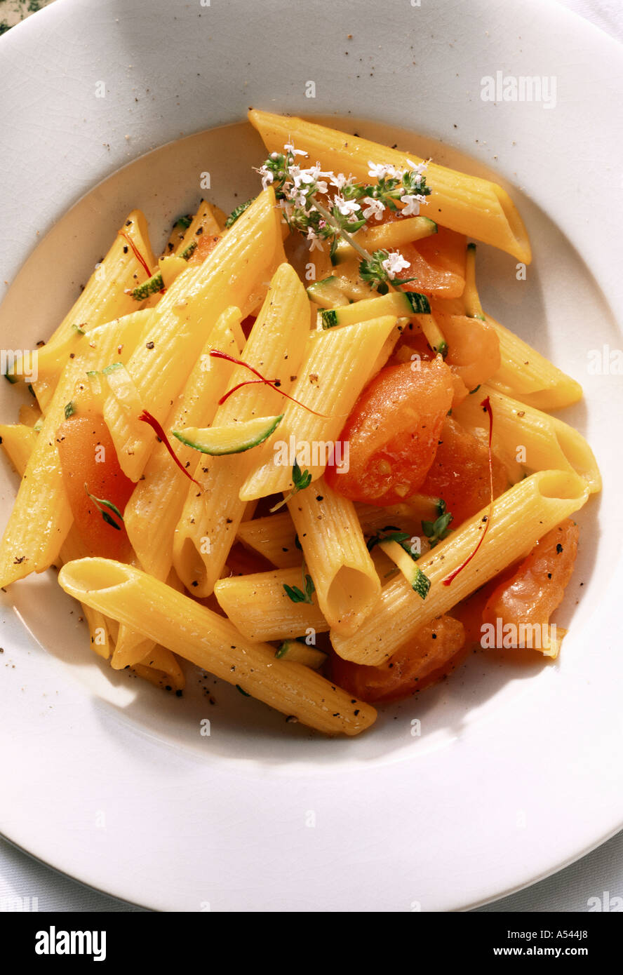Penne with tomatoes courgettes and saffron Stock Photo Alamy