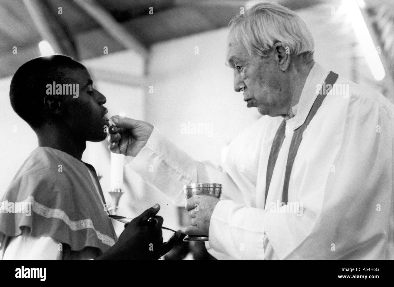 Painet hq1495 black and white religion american missionary giving sacrament man sunday mass shinyanga tanzania images bw Stock Photo