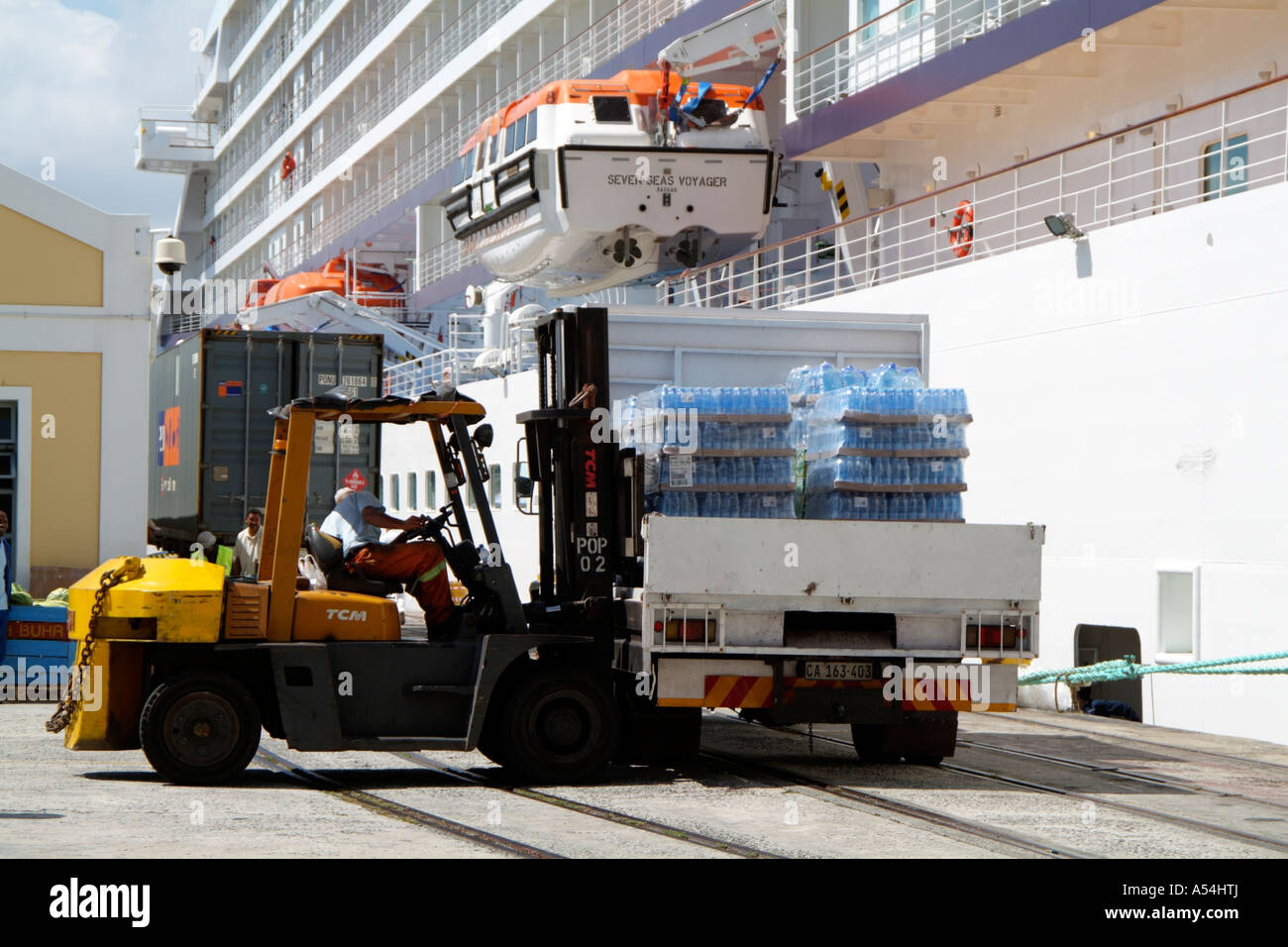 Forklift truck loading bottled water onto cruise ship in the Port of