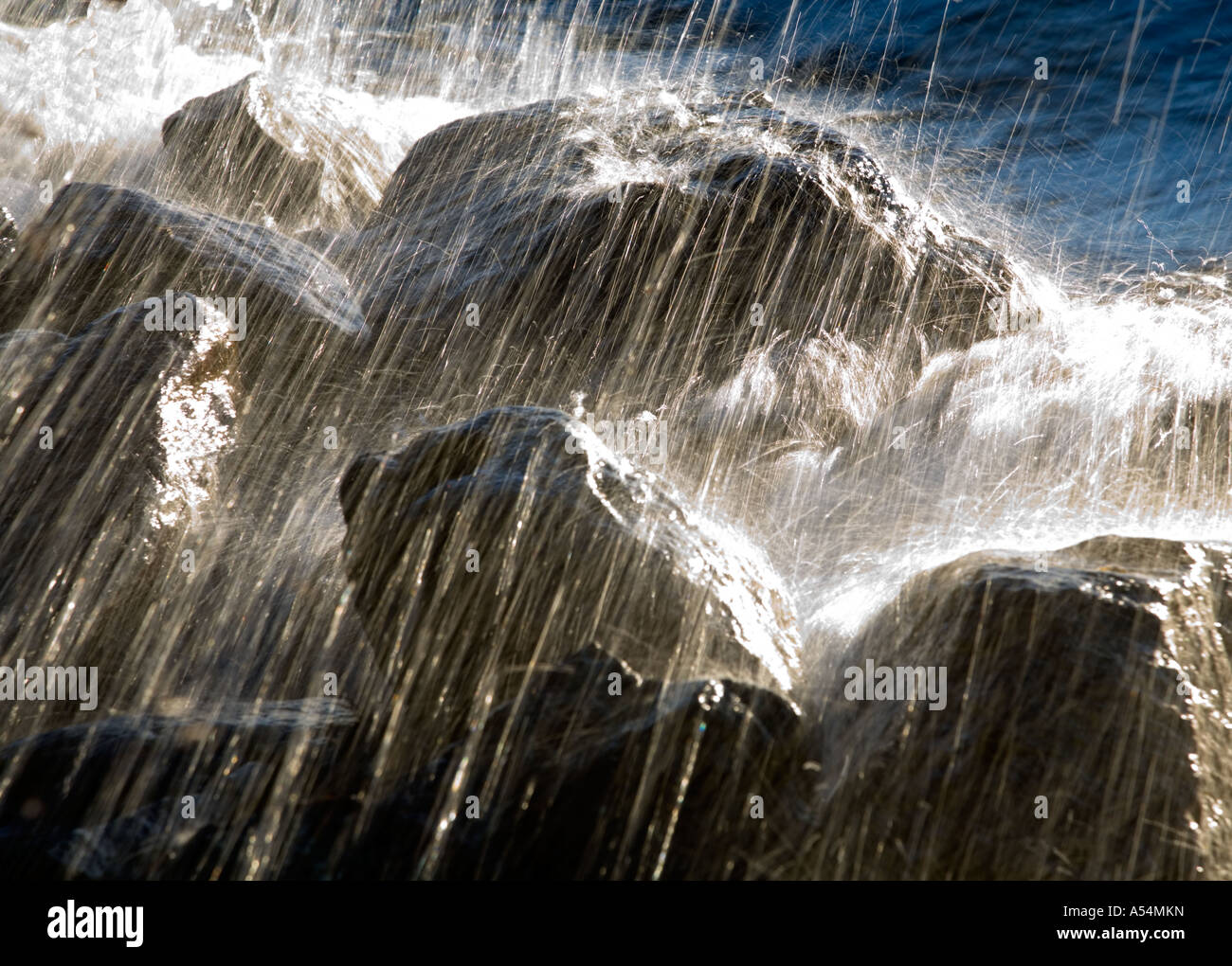 Waves splashing against stones Stock Photo - Alamy