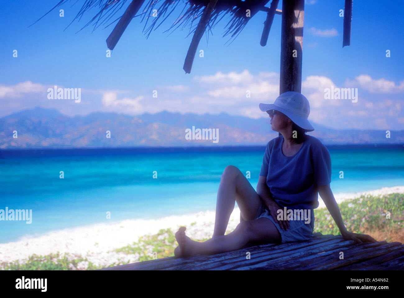 Woman relaxing in shade near beach on Lombok Island Indonesia Model Released Photo Stock Photo