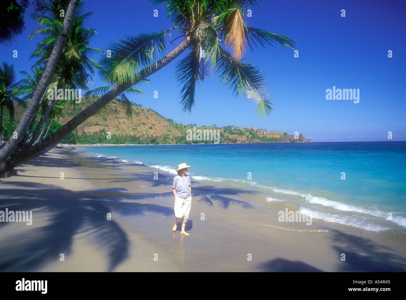 Woman walking along Pantai Nipah Beach on Lombok Island Indonesia Model Released Photo Stock Photo