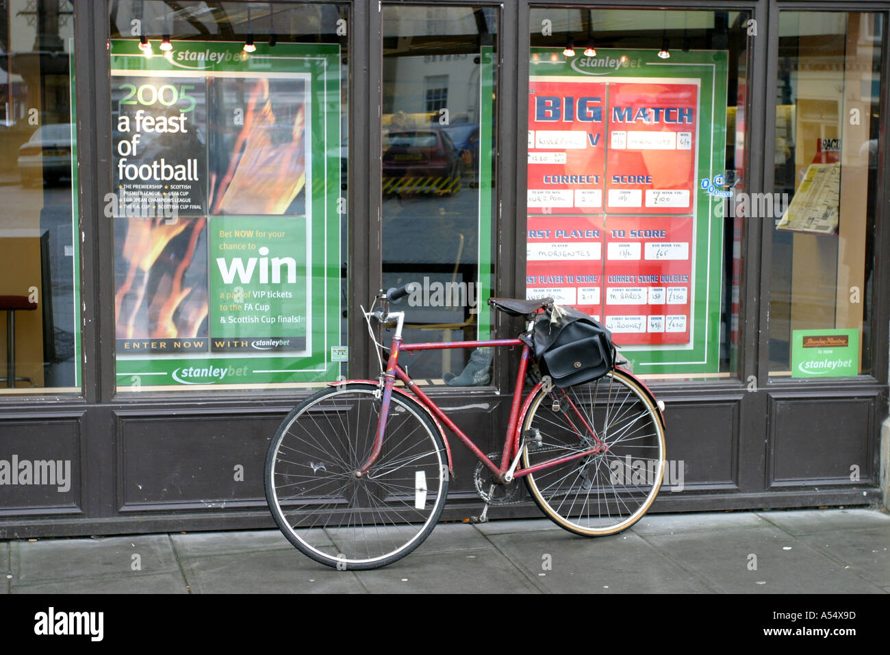 Bicycle propped up against a boomaker's window in Devizes Wiltshire Stock Photo