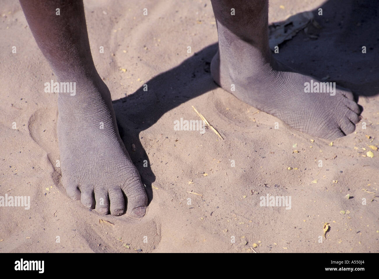 Feet of a black boy in sand Stock Photo