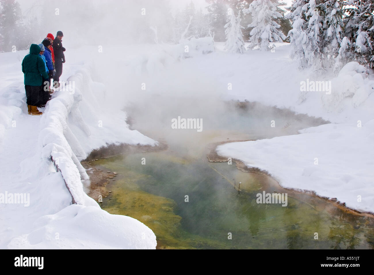 Yellowstone National Park Wyoming Winter visitors examine a hot spring in the West Thumb Geyser Basin Stock Photo