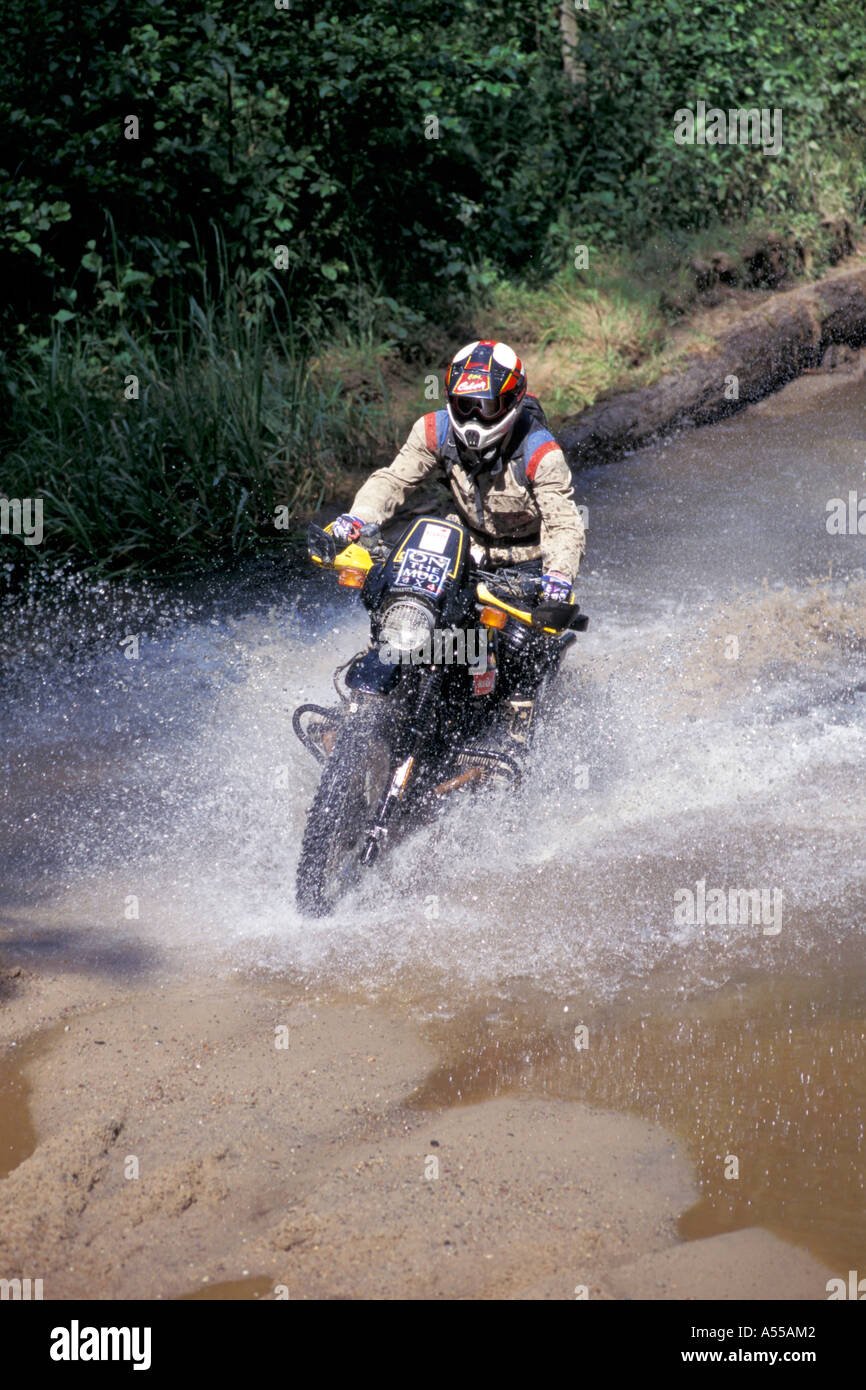 Enduro is driving through waterpuddle Stock Photo