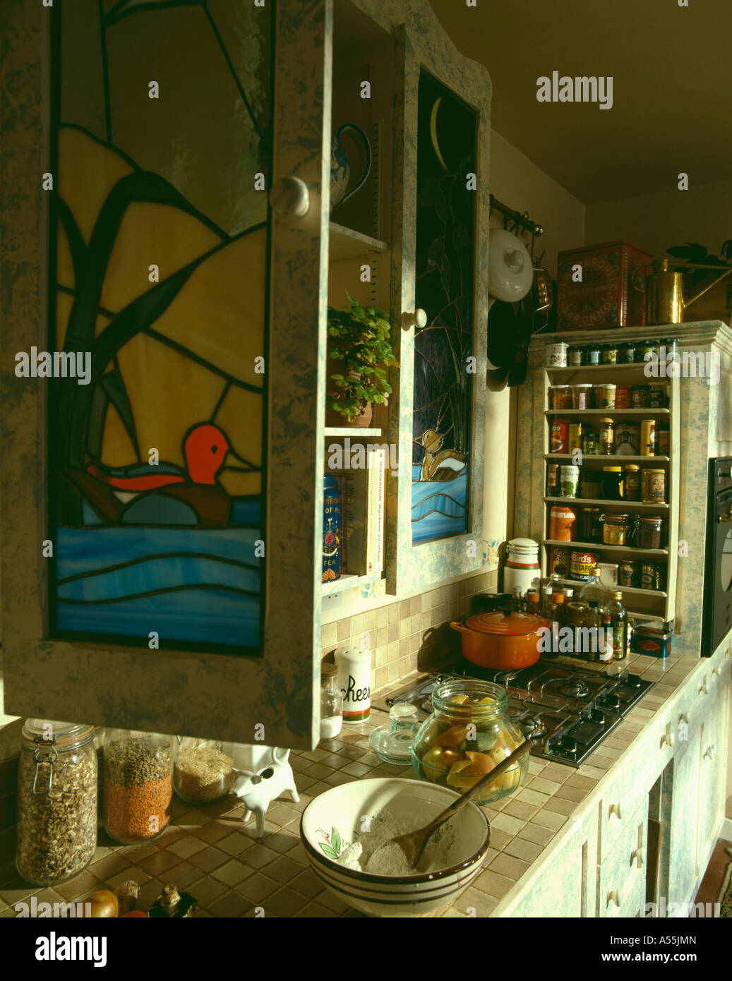 Closeup of stainedglass cupboard door above worktop with food