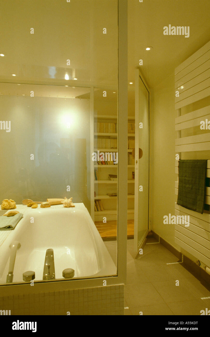 Modern white bathroom with opaque glass wall and open door with view of ...