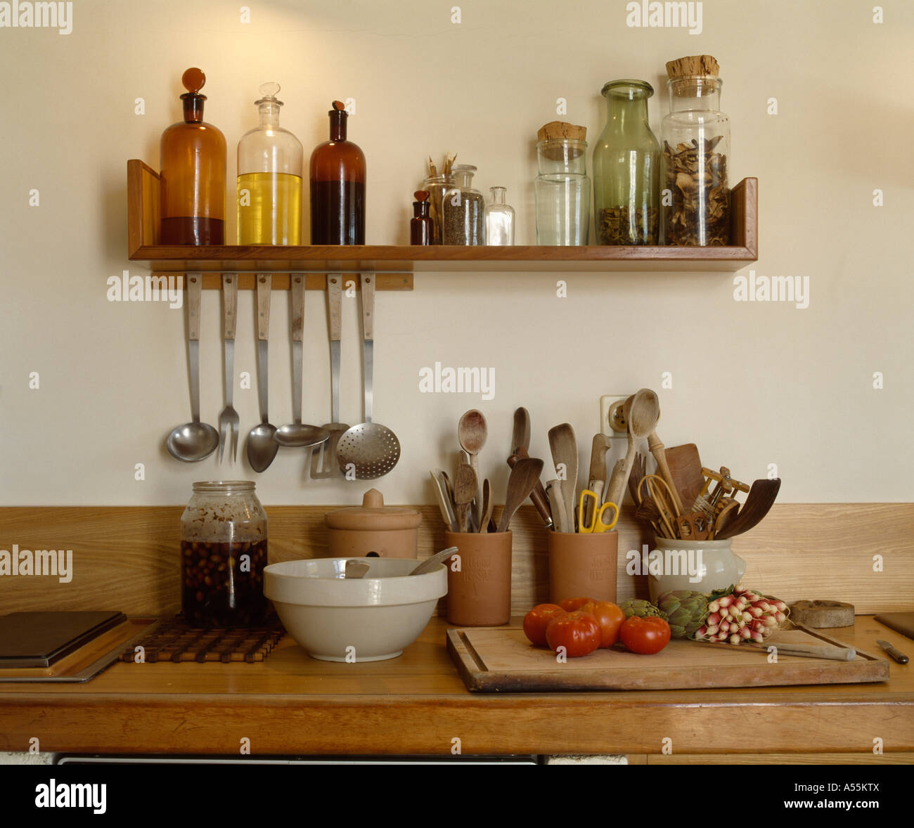 Closeup of wooden shelf with glass bottles of oil above worktop with