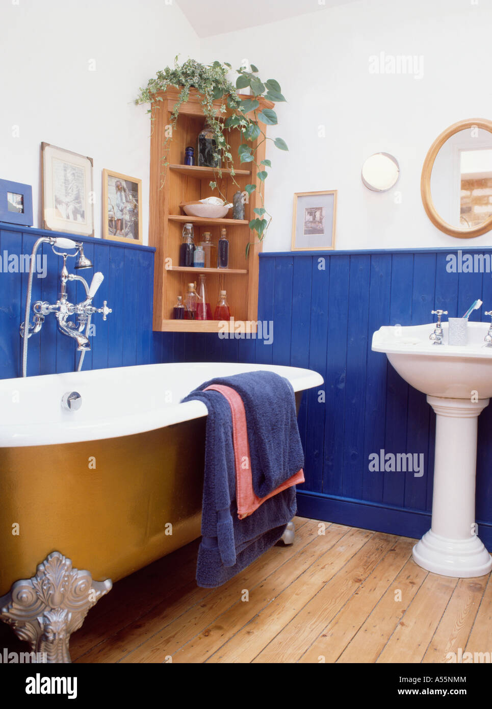 Freestanding bath on wooden floor in traditional bathroom with blue