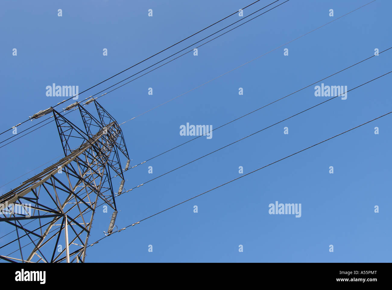 Electricity pylon and power lines with a plain blue sky Stock Photo - Alamy