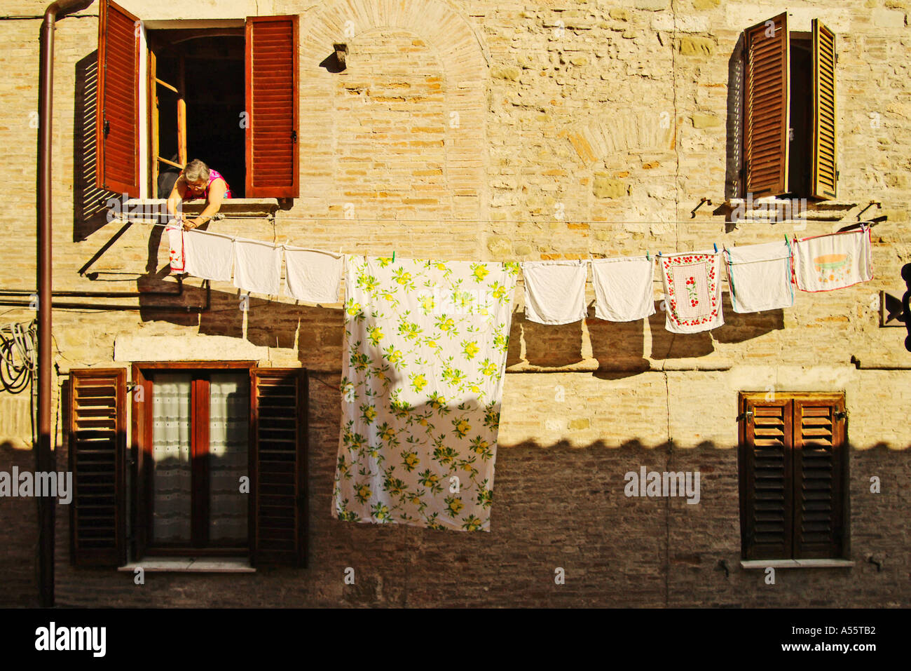 An Italian lady hangs out the daily wash Clothes dryers are almost none