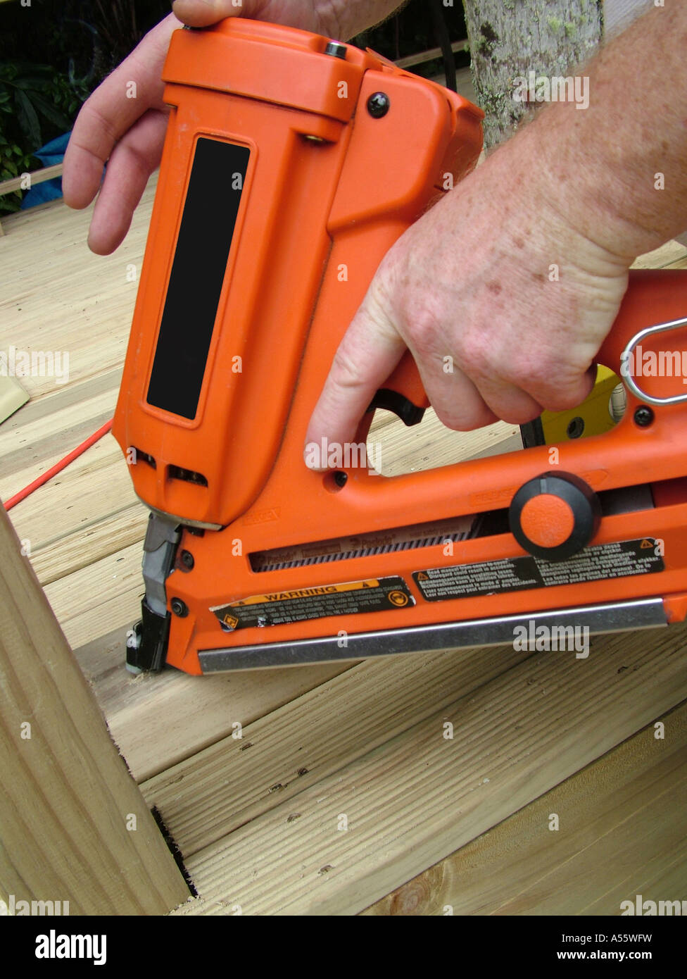 workers hands holding Paslode nail gun, framing gun Stock Photo Alamy