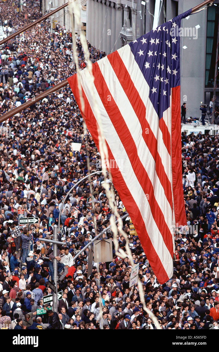 American flag hanging over crowd at ticker tape parade Stock Photo