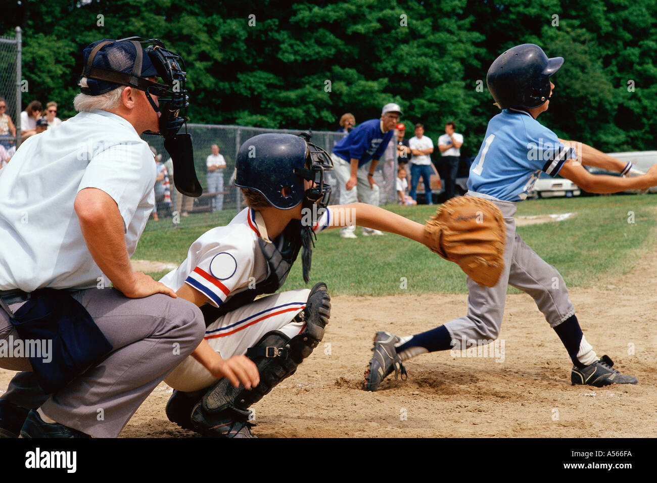 Little League batter swinging at ball Stock Photo