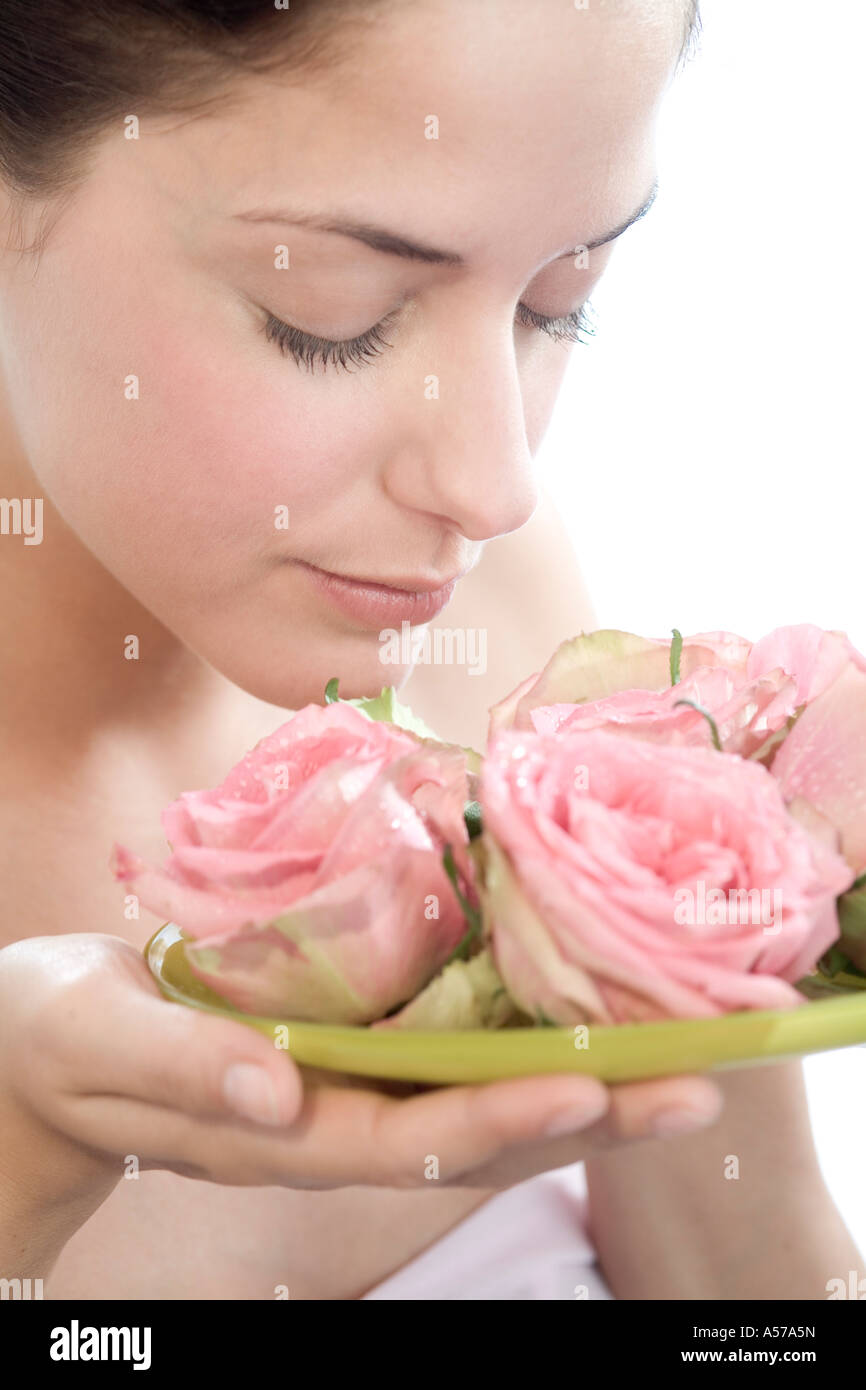 Young woman smelling rose flowers, eyes closed, close-up Stock Photo ...