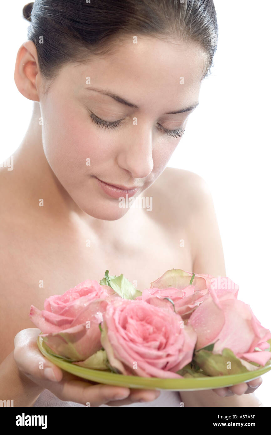 Young woman smelling rose flowers, eyes closed, close-up Stock Photo ...