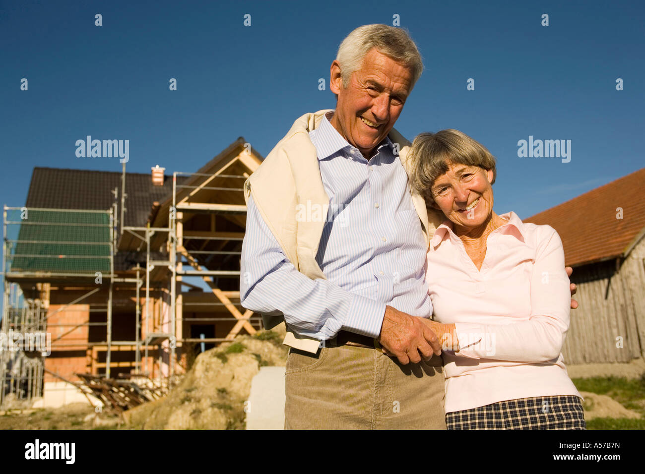 Senior couple in front of partially built house Stock Photo - Alamy