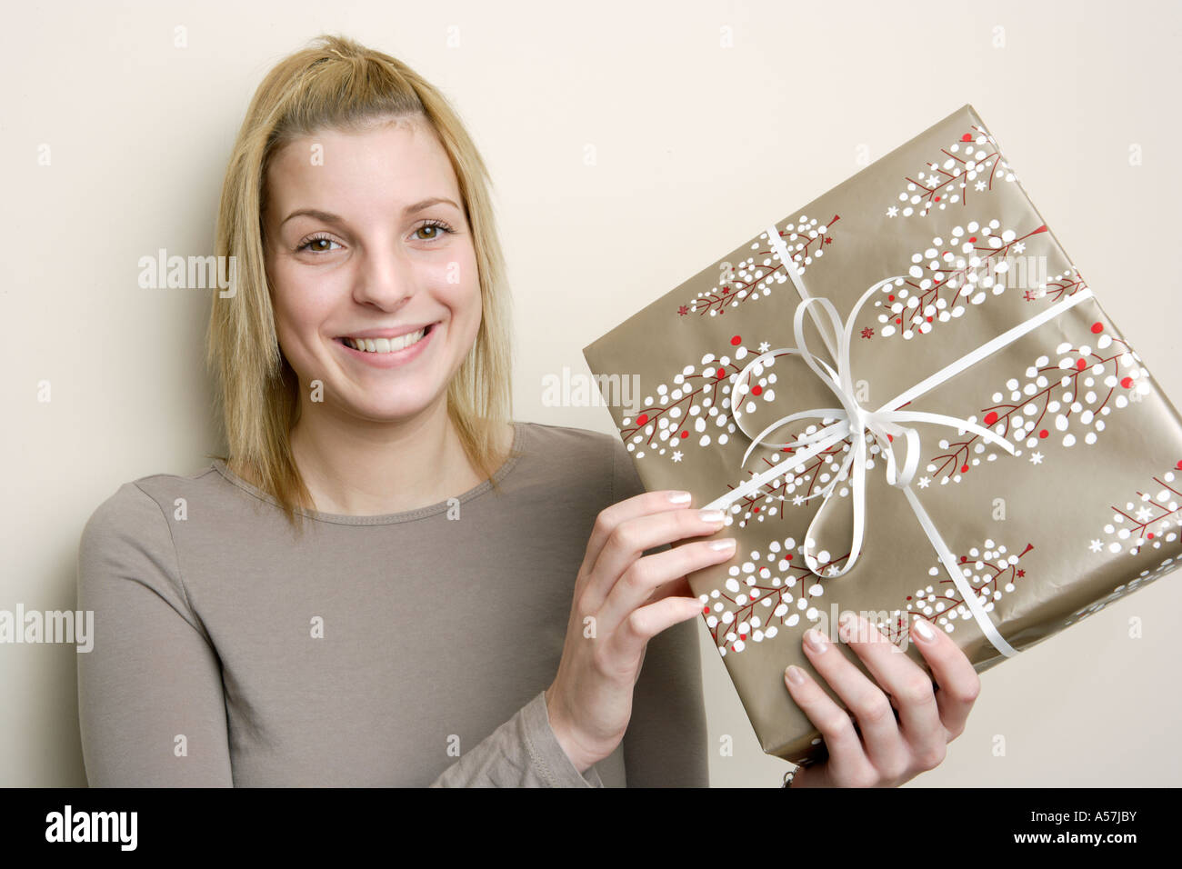 Young woman holding gift Stock Photo - Alamy