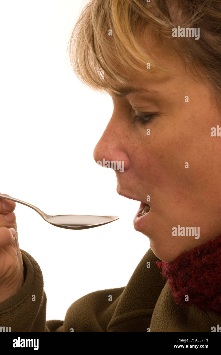 Woman taking cough syrup Stock Photo Alamy