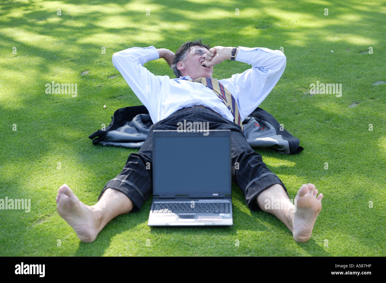 Manager lying on green Stock Photo