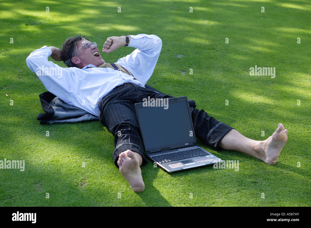 Manager lying on green Stock Photo