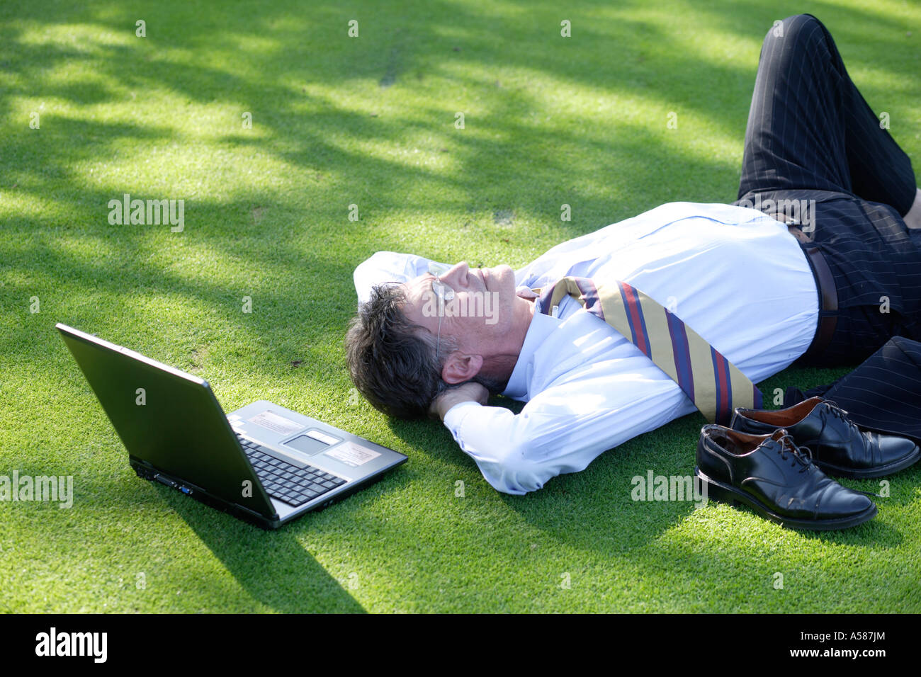 Manager lying on green Stock Photo