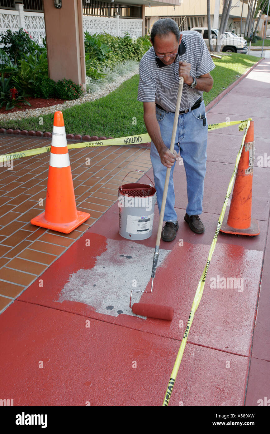 Miami Beach Florida,South Beach,Ocean Drive,Hispanic man men male,condo  maintenance manager,paints street,sidewalk red,roller,FL070222001 Stock  Photo - Alamy