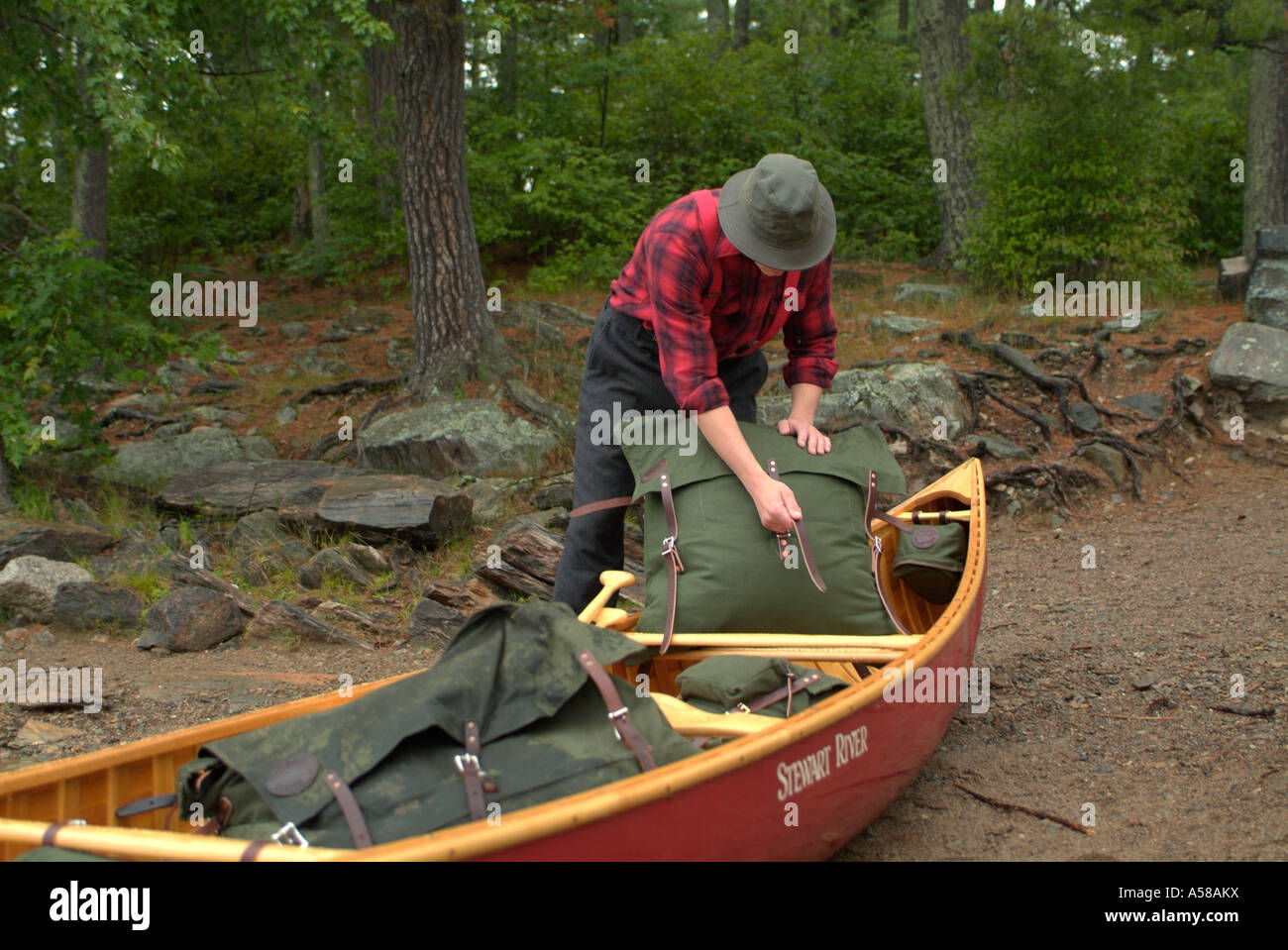 Canoer Loading his pack in Boundary Waters Canoe Area Wilderness BWCAW Minnesota Stock Photo