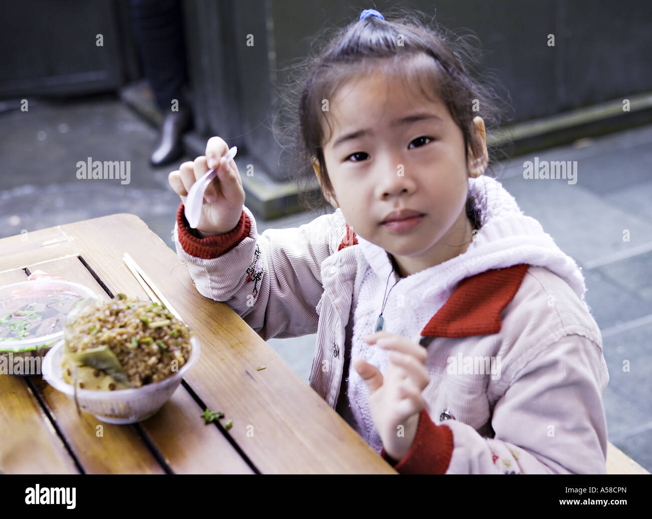 CHINA SHANGHAI Young Chinese girl eating a lunch of fried rice and miso