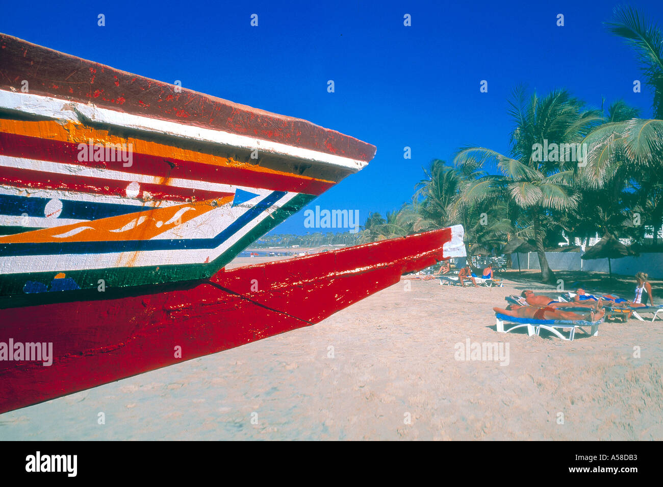 Women in colorful traditional clothes wait to collect fish from boat on  beach Bakau The Gambia Stock Photo - Alamy