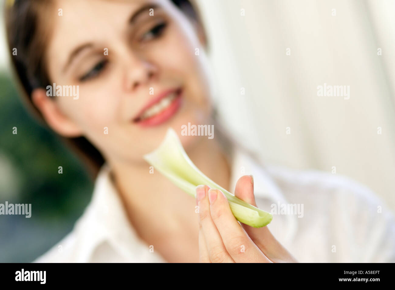 Girl eating piece of celery Stock Photo Alamy