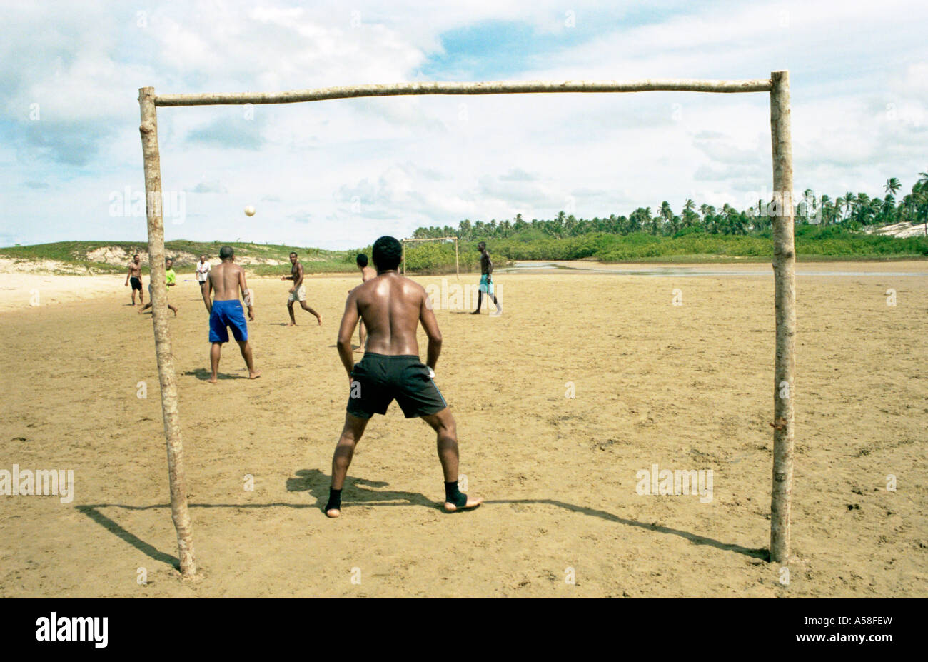 Colour landscape image of men playing soccer on beach in Bahia,Brazil. Stock Photo