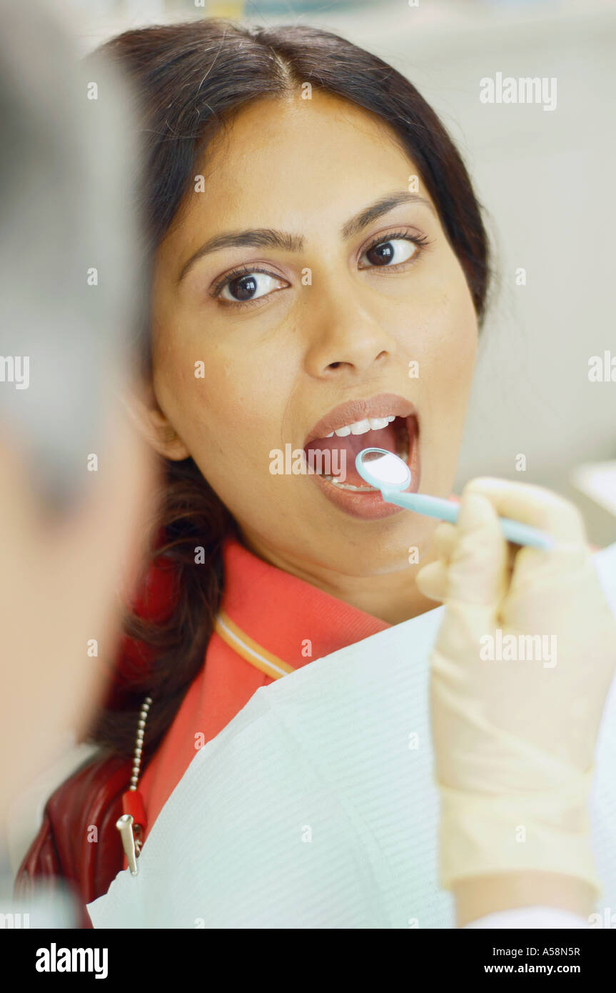 Dentist holding dental mirror in female patient s mouth Stock Photo - Alamy