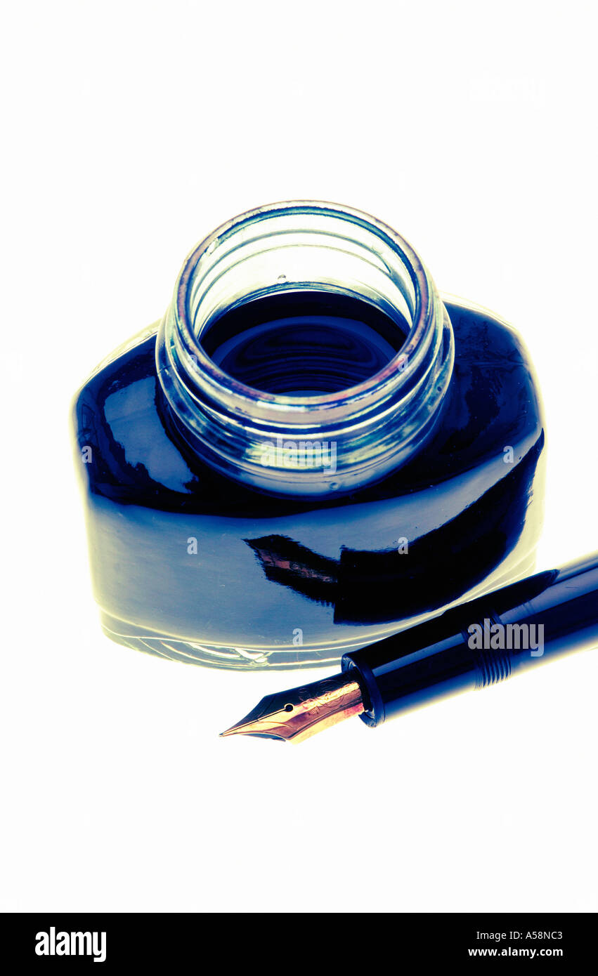Open bottle of ink with a black fountain pen against white background ...