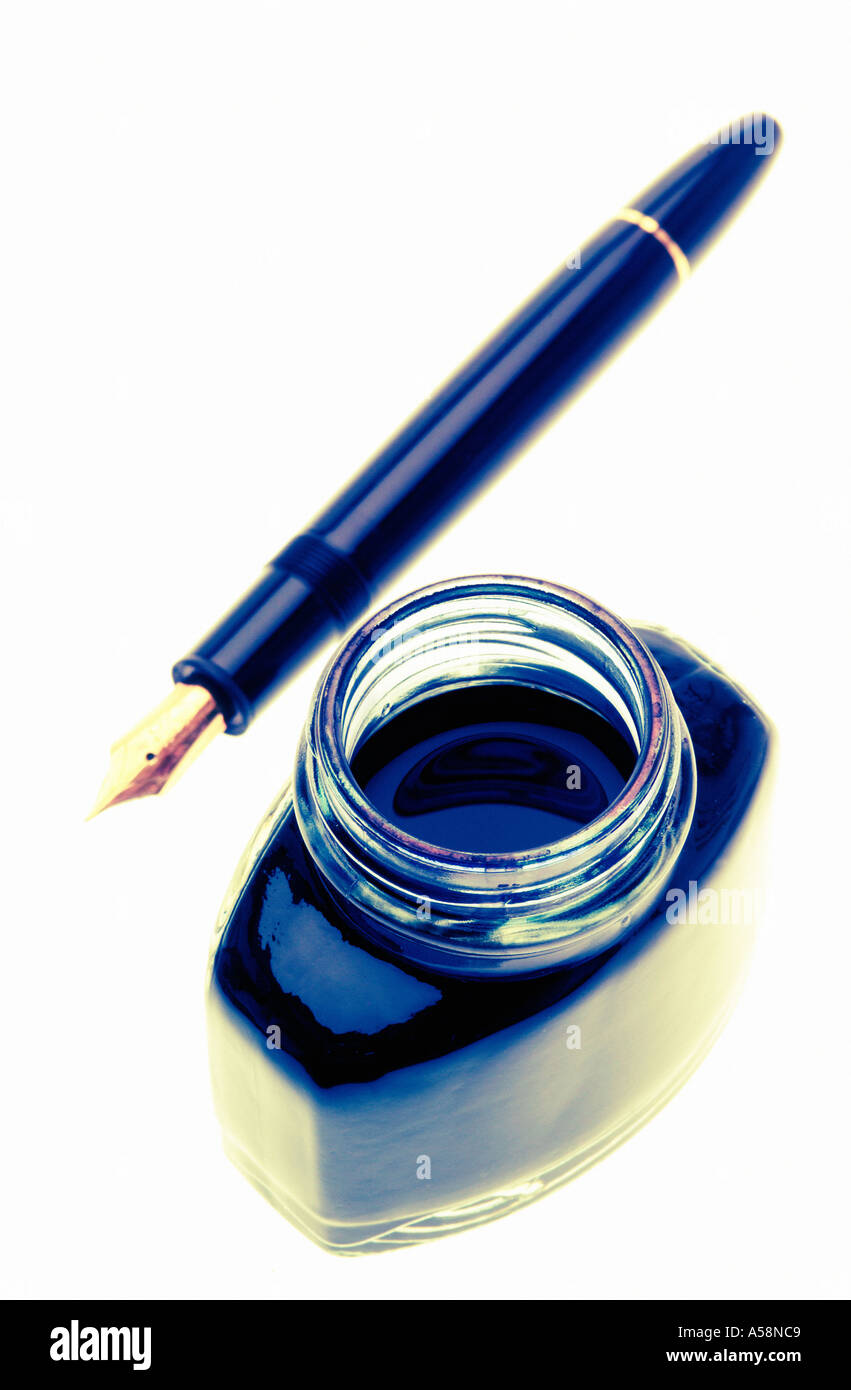 Open bottle of ink with a black fountain pen against white background ...