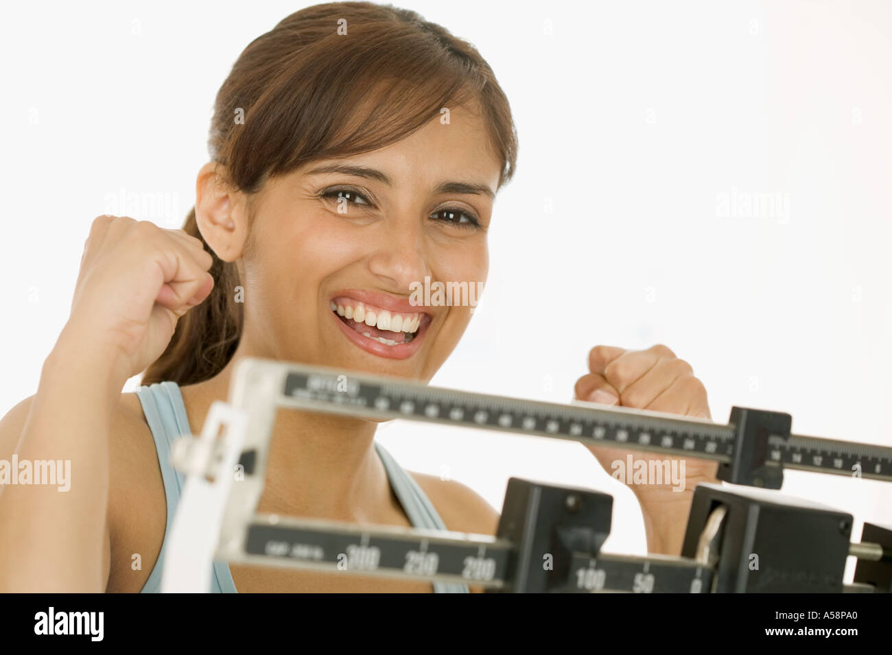 Portrait of woman weighing on scale Stock Photo