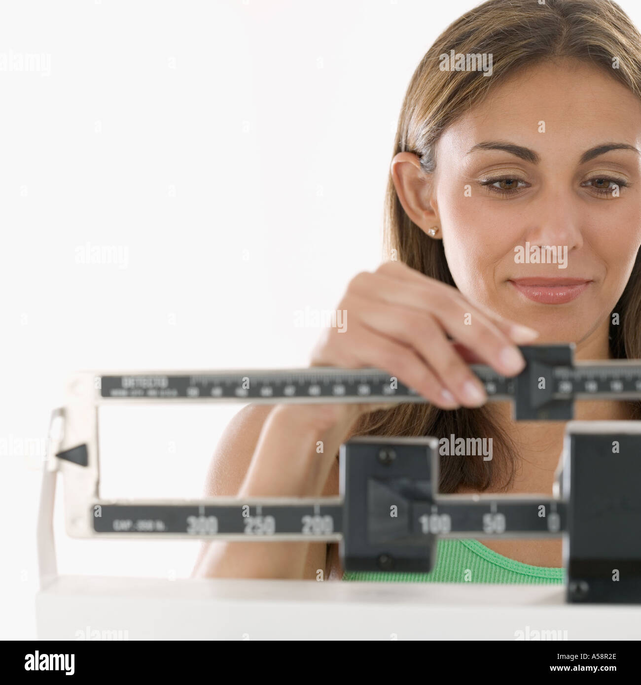 Woman weighing herself on scale Stock Photo