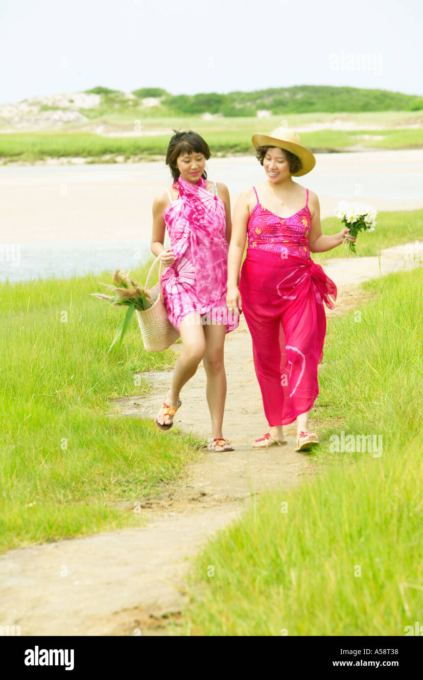 Two women walking on beach Stock Photo - Alamy