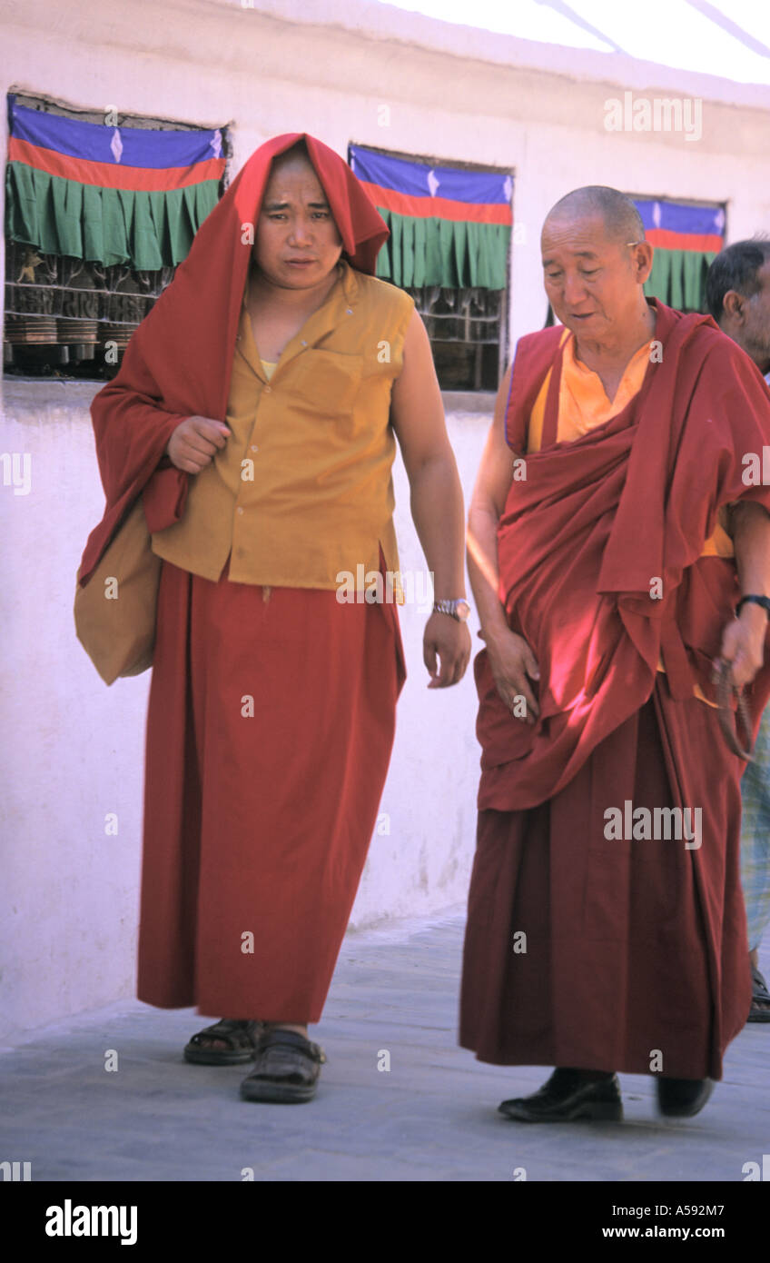 Two pilgrims walking around Buddhist Stupa of Bodhnath Kathmandu Nepal Stock Photo