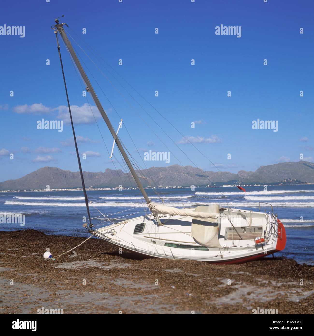 Beached yacht, following stormy weather, Bay of Pollenca looking NW towards Pollenca , Mallorca. Stock Photo