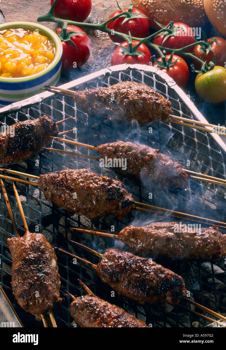 Beef kebabs cooking on BBQ with sweetcorn relish tomatoes in b/g Stock