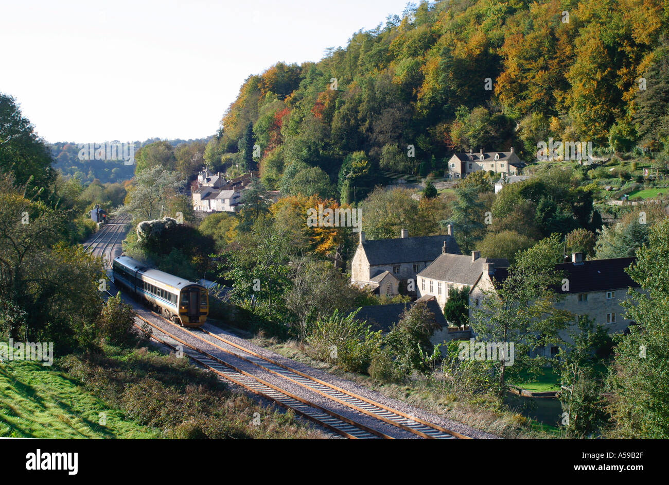 Modern commuter train passes old stone houses, Chalford