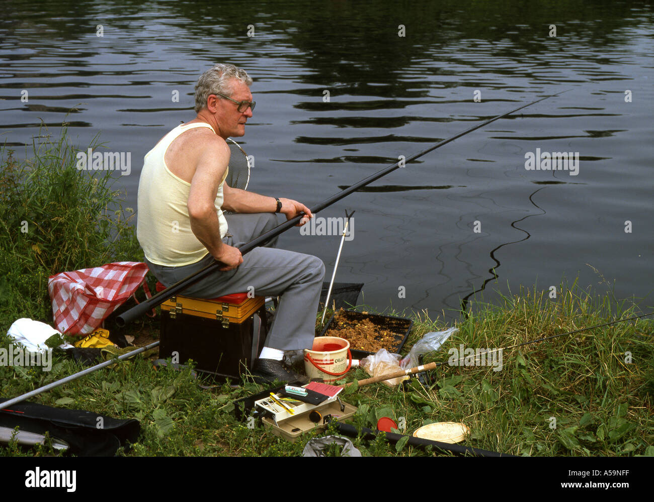 Man fishing on canal using a roach pole in warm weather Stock Photo - Alamy