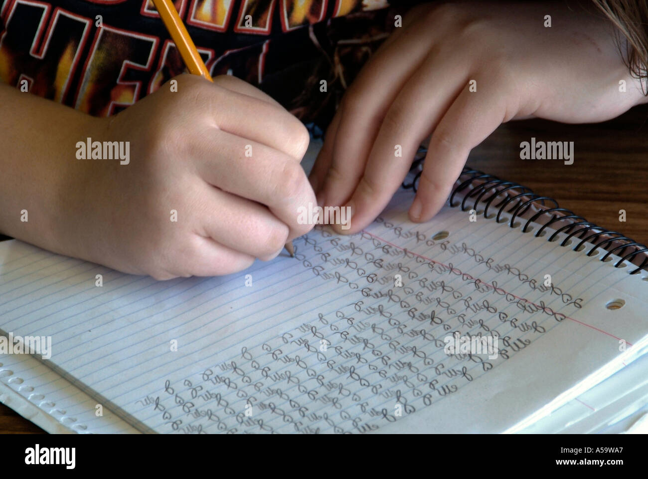 High school female practices handwriting in English class Stock Photo