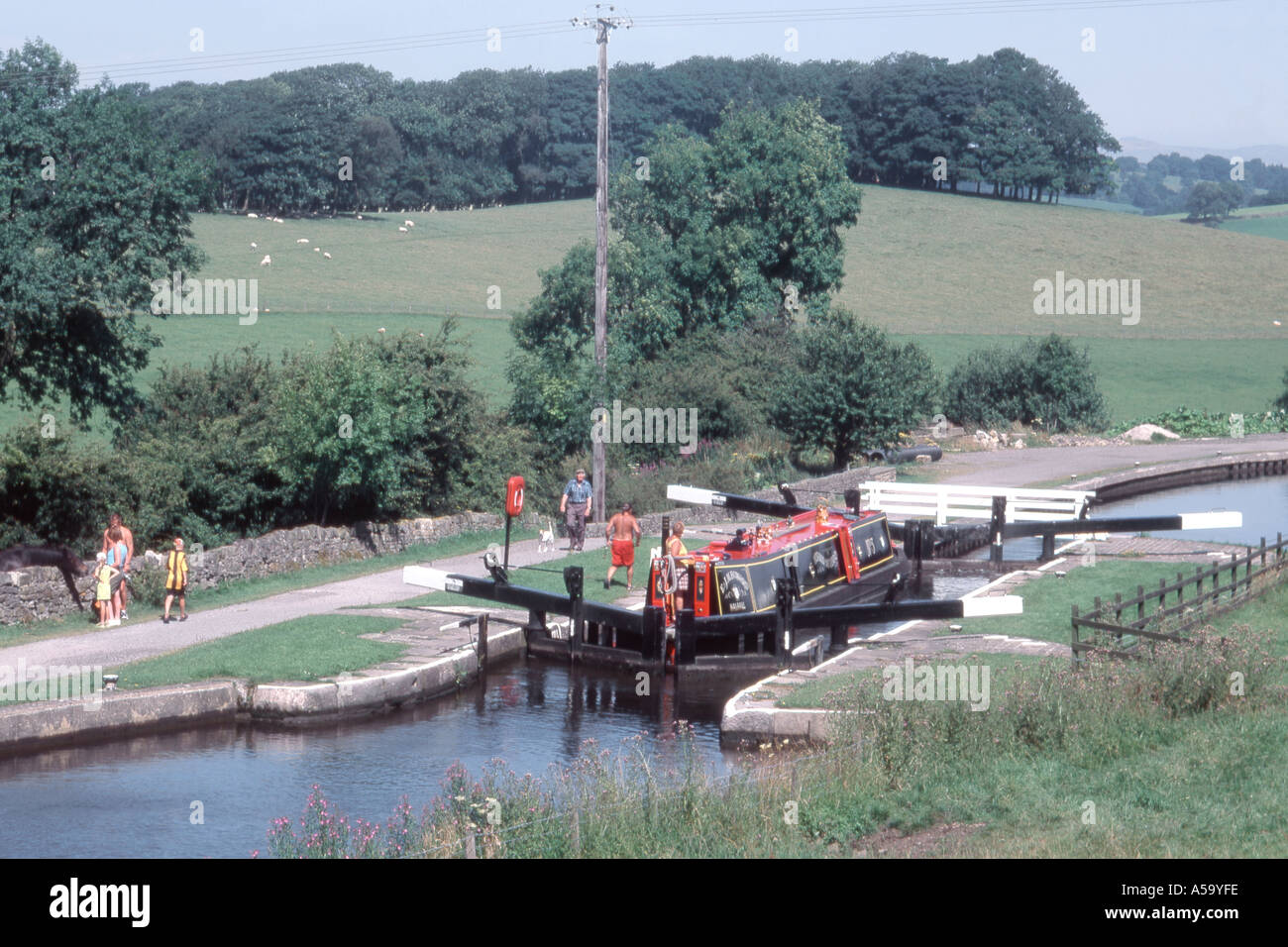 A holiday narrowboat in Greenberfield middle Lock high in the Peninnes on the Leeds liverpool Canal Stock Photo