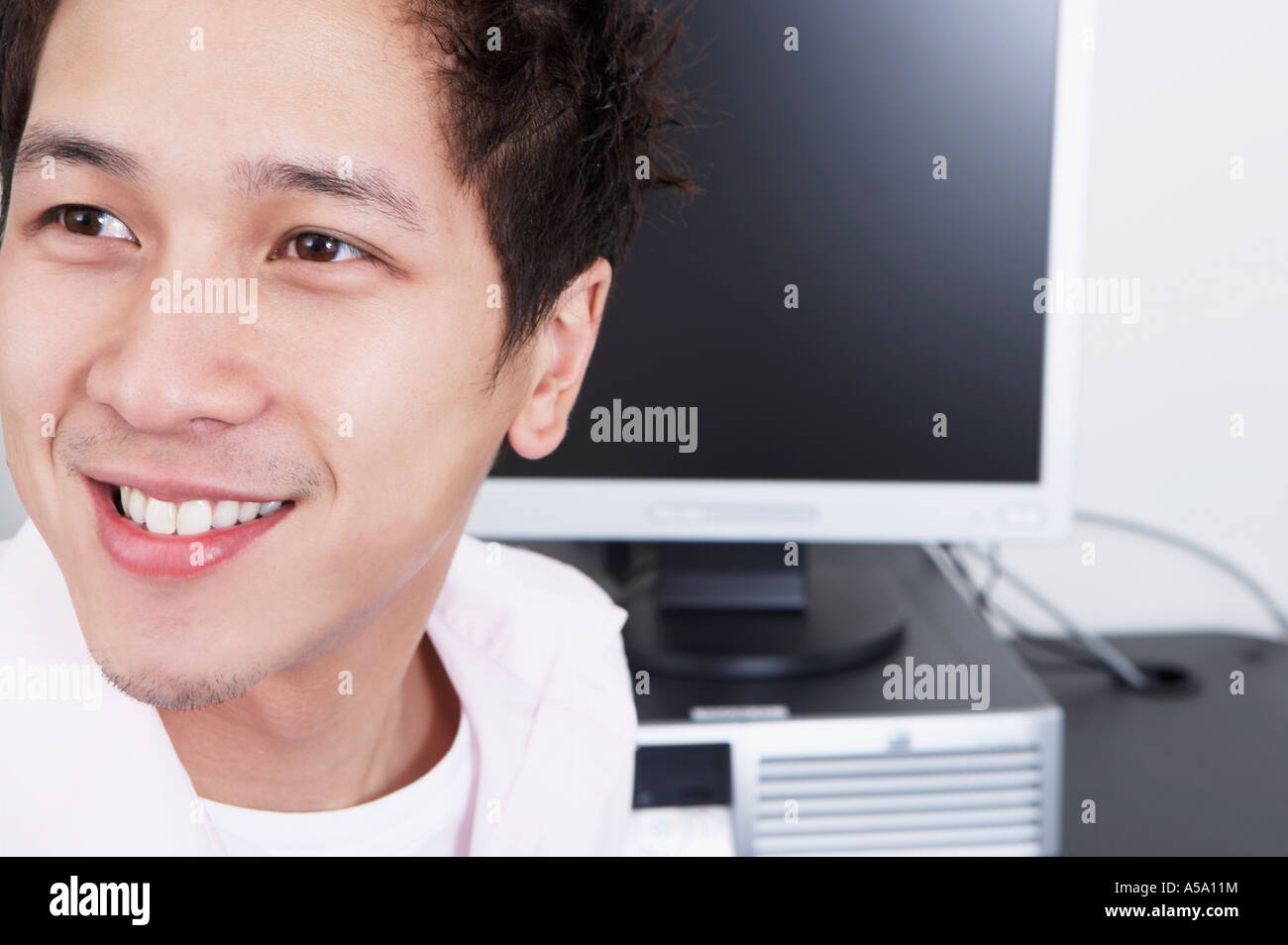 Close up of young Asian man next to computer Stock Photo - Alamy