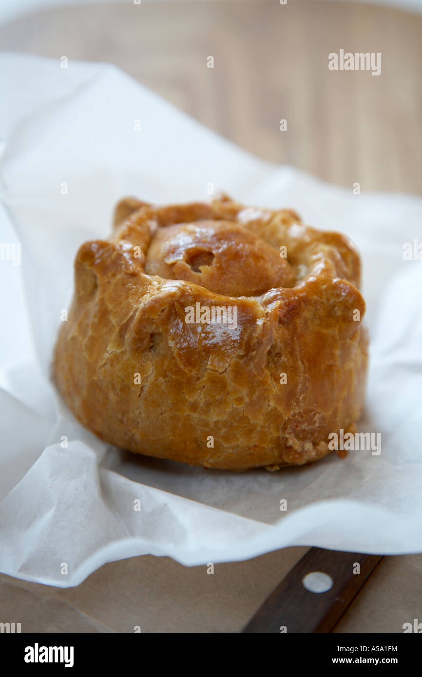 Pork Pie unwrapped on a wooden surface. Stock Photo