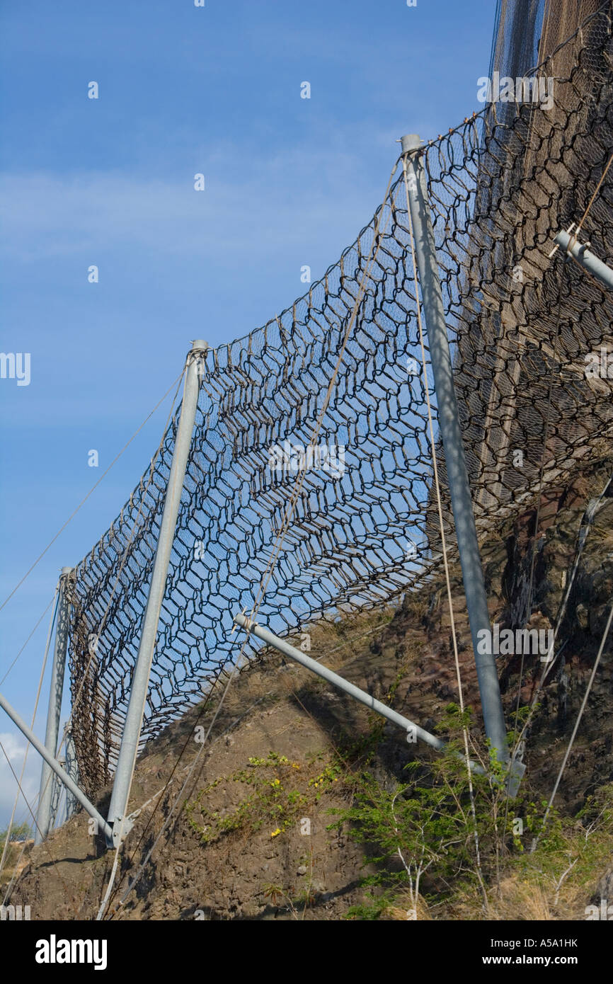 Defensive wire netting against rock fall danger on coastal road in Réunion Stock Photo
